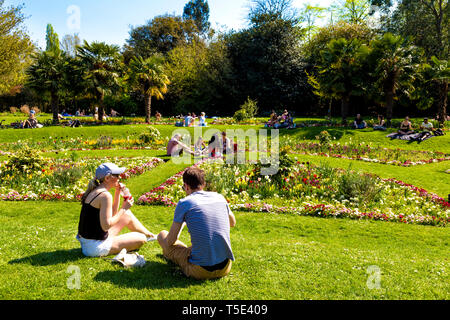 April 2019 21-Paar in einem Park sitzend, bei einem Picknick, Menschen sitzen in der Sonne während der Bank Holiday Hitzewelle in Victoria Park, London, UK Stockfoto