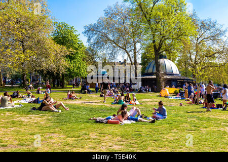 21. April 2019 - Die Leute saßen auf dem Gras in der Sonne außerhalb der Pavillon Cafe während Bank Holiday Hitzewelle in Victoria Park, London, UK Stockfoto