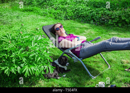 Eine Frau in Liege mit Hund Stockfoto