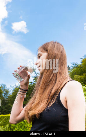 Teenager-Mädchen trinken ein Glas Wasser Stockfoto