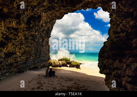 Erwachsene paar Indonesische Leute sitzen in einer Höhle auf dem tropischen Strand auf Hintergrund Landschaft Natur Landschaft die Insel Bali, Indonesien Stockfoto