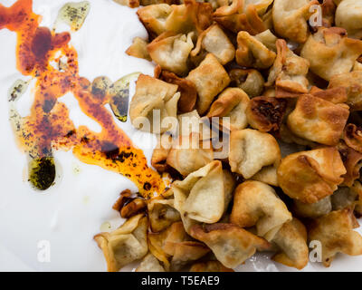 Schließen Sie herauf Bild der Fried türkische Manti mit rotem Pfeffer, Tomatensauce, Joghurt und Minze. Platte der traditionellen türkischen Küche. Ansicht von oben Stockfoto