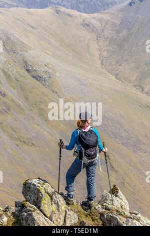 Eine einsame weibliche Wanderer auf der Suche nach schwarzen Segel Pass von Red Pike, im englischen Lake District National Park. Stockfoto