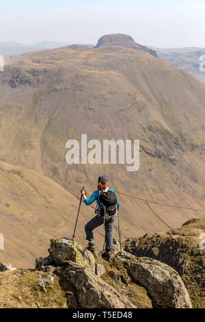 Eine einsame weibliche Wanderer auf dem Weg zu den Gipfeln des Kirk fiel und Great Gable suchen, mit schwarzen Segeln, im englischen Lake District National Park. Stockfoto