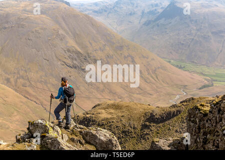 Eine einsame weibliche Wanderer auf dem Weg zu den Pisten von Kirk sank von Red Pike im englischen Lake District National Park. Stockfoto