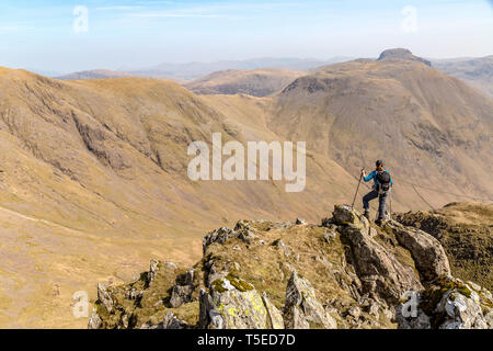 Eine einsame weibliche Wanderer auf dem Gipfel der Säule, Kirk fiel und Great Gable suchen, mit schwarzen Segeln, im englischen Lake District National Park. Stockfoto