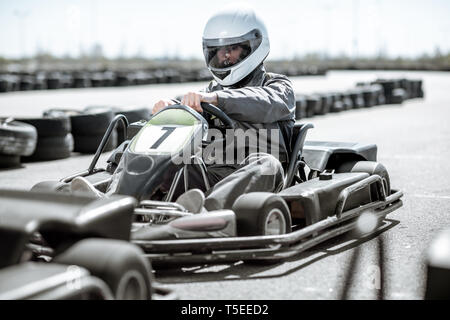 Racer in Sportkleidung und Schutzhelm fahren gehen-kart auf der Spur Stockfoto