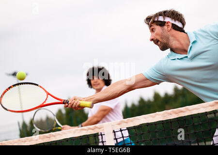 Gruppe von gesunden glücklichen Freunde an der Verein Tennis spielen. Stockfoto