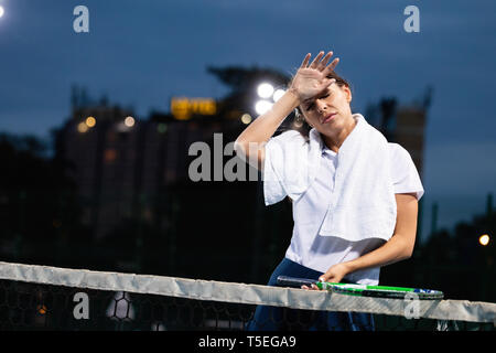 Portrait von Frau wischen Schweiß nach intensiver Praxis in der Tennisplatz Stockfoto