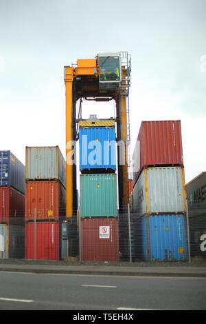 Belfast, County Antrim, Nordirland, 29, März, 2019 - Bunte Container sind, gesehen im Hafen von Belfast, Nordirland Irealnd gestapelt. Straddle Carrier werden am häufigsten für das Stapeln und Verschieben von Containern statt direkt Verladen auf Lkw eingesetzt. Paul McErlane Stockfoto