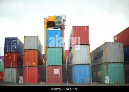 Belfast, County Antrim, Nordirland, 29, März, 2019 - Bunte Container sind, gesehen im Hafen von Belfast, Nordirland Irealnd gestapelt. Straddle Carrier werden am häufigsten für das Stapeln und Verschieben von Containern statt direkt Verladen auf Lkw eingesetzt. Paul McErlane Stockfoto