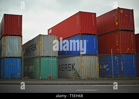 Belfast, County Antrim, Nordirland, 29, März, 2019 - Bunte Container sind, gesehen im Hafen von Belfast, Nordirland Irealnd gestapelt. Straddle Carrier werden am häufigsten für das Stapeln und Verschieben von Containern statt direkt Verladen auf Lkw eingesetzt. Paul McErlane Stockfoto