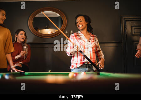 Kleine Gruppe von weiblichen Freunde, spielen eine Partie Pool, ein Spielzimmer im Haus. Stockfoto