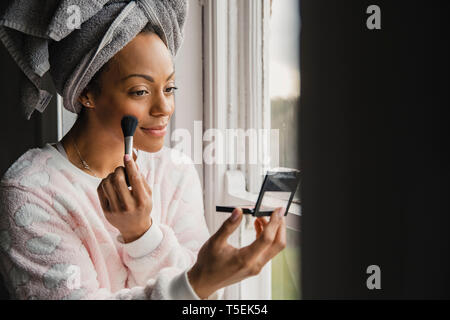 Mitte nach gemischten Rasse Frau Anwendung Make-up während Ihrer täglichen morgendlichen Routine. Stockfoto