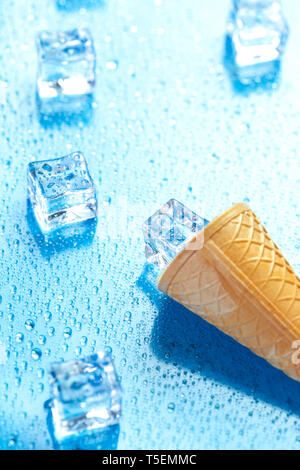 Eis und geschmolzenen Eiswürfel auf frischen blauen Hintergrund Stockfoto