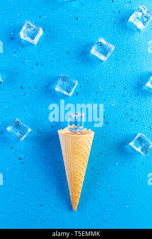 Eis mit Eiswürfeln auf blauem Hintergrund geschmolzen Stockfoto