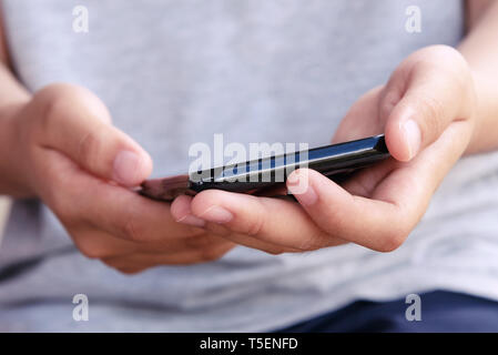 In der Nähe der Hände halten Smartphone Stockfoto