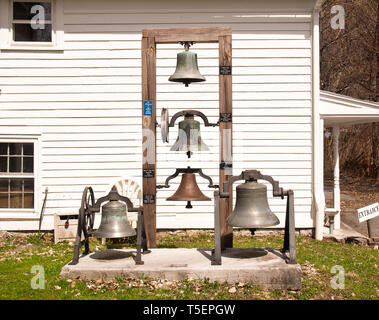Marcellus, New York, USA. April 17, 2019. Antike Glocken auf Display hinter dem Tefft-Steadman Haus in Marcellus, NY Stockfoto