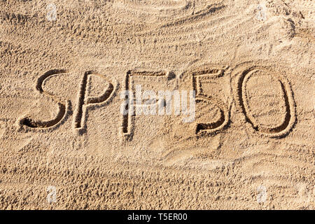 Sun Schutz Faktor 50 Konzept. SPF 50 Wort am Strand geschrieben. Stockfoto