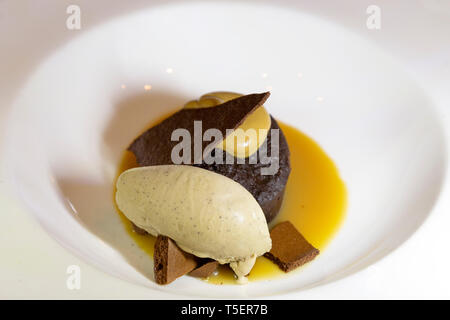 Schokoladenpudding mit Eis serviert. Das Gericht hat eine karamellsauce. Stockfoto