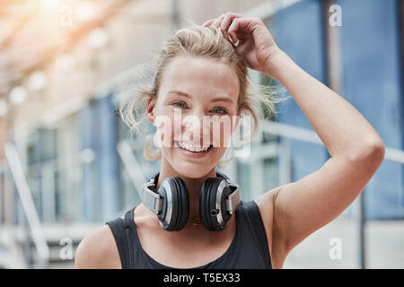 Porträt der lächelnde junge Frau mit Kopfhörern Stockfoto
