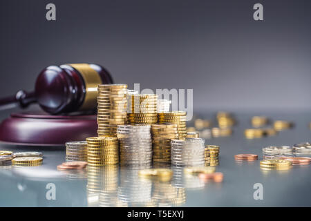 Türme mit Euro-Münzen und Gerechtigkeit Hammer im Hintergrund. Stockfoto