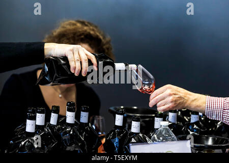 Abbildung, blinden Weinprobe Contest: Flasche Wein mit einer Hülse Ausblenden der Label und jemand etwas Wein in ein Glas gießen Stockfoto