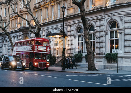 London, Großbritannien, 13. April 2019: Black Cab und einen Tee am Nachmittag Stadtrundfahrt in retro red Double Decker Bus auf einer Straße in London, Großbritannien, in der Dämmerung. Doppel Dez Stockfoto