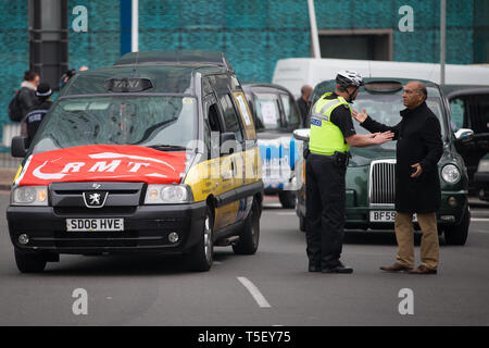 Polizisten direkten Verkehr als Taxis engagieren sich in einem "go slow" Protest auf dem Holloway Circus Kreisverkehr im Zentrum von Birmingham als Fahrer Protest über die Stadträte Pläne für eine neue saubere Luft Zone in Birmingham. Stockfoto