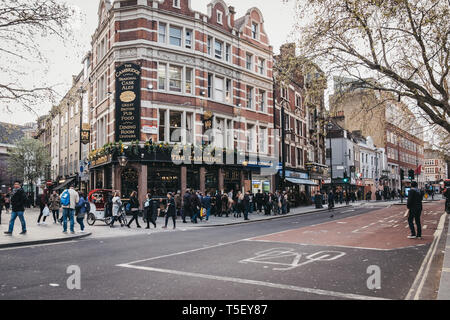 London, Großbritannien - 13 April, 2019: die Menschen gehen auf die Straße vor der Cambridge, einen traditionellen Pub von einzigartigen Charakter neben dem Palace Theater auf Stockfoto