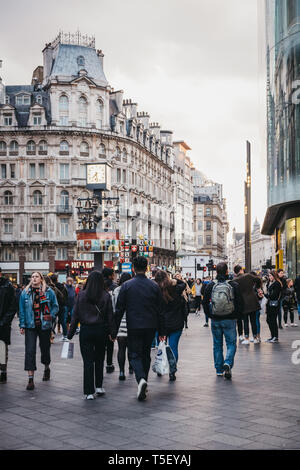London, Großbritannien - 13 April, 2019: Menschen zu Fuß auf dem Leicester Square, einem verkehrsberuhigten Platz im West End von London, in der Dämmerung. Es wurde in 1670 ein festgelegt Stockfoto