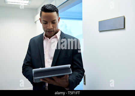 Geschäftsmann mit digitalen Tablet-PC in der Hotellobby Stockfoto