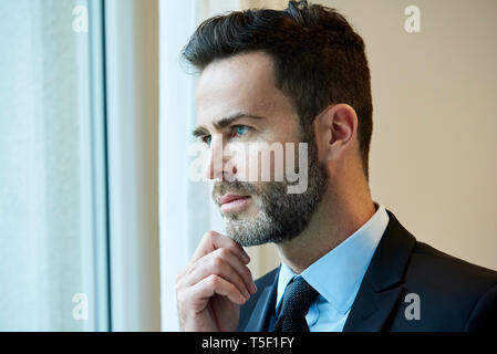 Unternehmer, die über Office Fenster Stockfoto