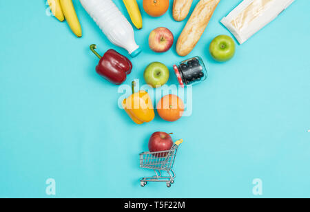 Frische Produkte in eine Miniatur Warenkorb fallen, Einkaufen auf einem Etat Konzept Stockfoto
