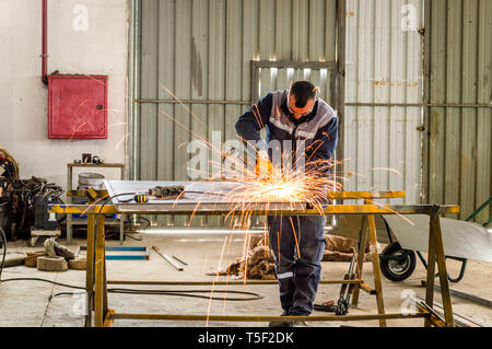 Schwerindustrie Arbeiter Schneiden von Metall mit der Fräse im Werk. Stockfoto