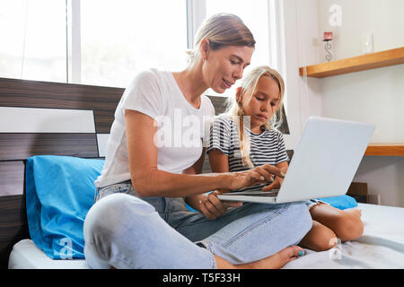Mutter und Tochter spielen auf Laptop Stockfoto