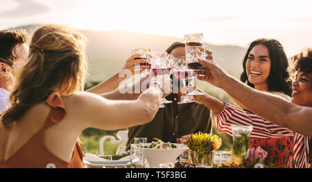 Gruppe junger Freunde toasten Getränke an einer Partei. Junge Freunde Drinks einen besonderen Anlass zu feiern. Stockfoto