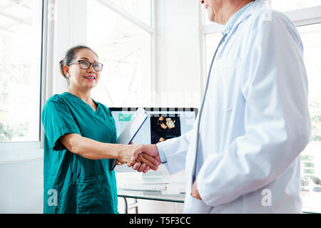 Krankenschwester und Arzt Händeschütteln Stockfoto