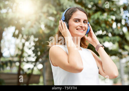 Portrait von fröhliche junge Frau in Kopfhörer Stockfoto