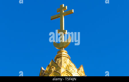 Vergoldete Kreuz auf einem Denkmal Stockfoto