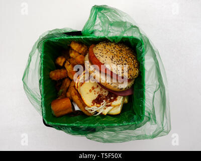 Fast food Abfall in einer biologisch abbaubaren Müllsack auf weißem Hintergrund Stockfoto