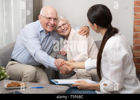 Gerne älteres Paar ihre Investitionen planen, mit finanziellen Berater. Abkommen Vereinbarung, unterzeichnet Vertrag mit Handshake Konzept Stockfoto
