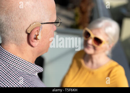 Ältere Menschen, Gehörlose Menschen verwendet ein Hörgerät. Zwei Menschen Gespräch Stockfoto