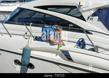 CANNES, Frankreich - April 2019: Person polieren die Lackierung eine Superyacht im Hafen von Cannes ist die Vorbereitung für die Charta Saison Stockfoto