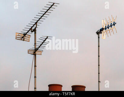 Drei TV-Antennen auf dem Dach bei Sonnenuntergang Stockfoto