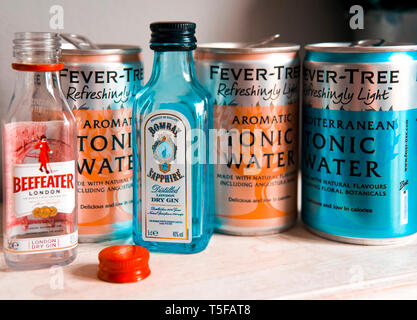 Leeren der Flasche Beefeater Gin Bombay Sapphire Gin mit leeren Dosen Fever-Tree Tonic Water Stockfoto