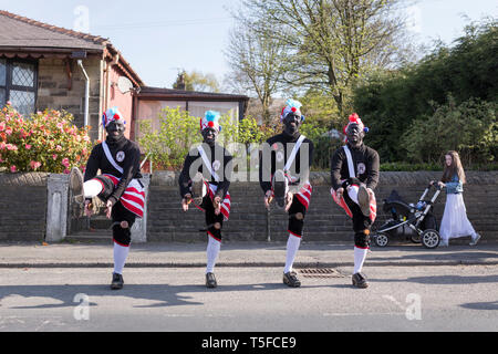 © Chris Bull. 20/04/19 Bacup, Lancashire, England. Die Morrismen der Britannia Coconutters Tanz Grenze Grenze in Bacup, Lancashire heute (Samstag, 20. April 2019). In einer Tradition zurückgehende Hunderte Jahre, jeden Ostersamstag Der morrismen haben heidnische Tänze Frühling zu begrüßen und böse Winter Spirituosen. Die Coconutters Namen aus der Zeit, als Bergleute würde Kokosnussschalen auf die Knie tragen zum Schutz in den Gruben stammt. Unterlegen Sie ihre Gesichter sie von bösen Geistern zu tarnen und auch der Bergbau Traditionen der Gegend zu reflektieren. Stockfoto