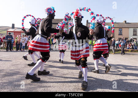 © Chris Bull. 20/04/19 Bacup, Lancashire, England. Die Morrismen der Britannia Coconutters Tanz Grenze Grenze in Bacup, Lancashire heute (Samstag, 20. April 2019). In einer Tradition zurückgehende Hunderte Jahre, jeden Ostersamstag Der morrismen haben heidnische Tänze Frühling zu begrüßen und böse Winter Spirituosen. Die Coconutters Namen aus der Zeit, als Bergleute würde Kokosnussschalen auf die Knie tragen zum Schutz in den Gruben stammt. Unterlegen Sie ihre Gesichter sie von bösen Geistern zu tarnen und auch der Bergbau Traditionen der Gegend zu reflektieren. Stockfoto