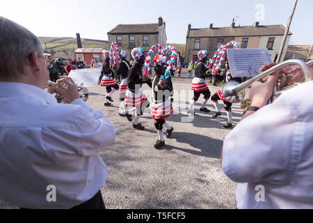 © Chris Bull. 20/04/19 Bacup, Lancashire, England. Die Morrismen der Britannia Coconutters Tanz Grenze Grenze in Bacup, Lancashire heute (Samstag, 20. April 2019). In einer Tradition zurückgehende Hunderte Jahre, jeden Ostersamstag Der morrismen haben heidnische Tänze Frühling zu begrüßen und böse Winter Spirituosen. Die Coconutters Namen aus der Zeit, als Bergleute würde Kokosnussschalen auf die Knie tragen zum Schutz in den Gruben stammt. Unterlegen Sie ihre Gesichter sie von bösen Geistern zu tarnen und auch der Bergbau Traditionen der Gegend zu reflektieren. Stockfoto