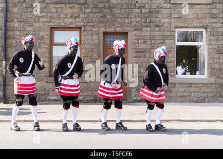 © Chris Bull. 20/04/19 Bacup, Lancashire, England. Die Morrismen der Britannia Coconutters Tanz Grenze Grenze in Bacup, Lancashire heute (Samstag, 20. April 2019). In einer Tradition zurückgehende Hunderte Jahre, jeden Ostersamstag Der morrismen haben heidnische Tänze Frühling zu begrüßen und böse Winter Spirituosen. Die Coconutters Namen aus der Zeit, als Bergleute würde Kokosnussschalen auf die Knie tragen zum Schutz in den Gruben stammt. Unterlegen Sie ihre Gesichter sie von bösen Geistern zu tarnen und auch der Bergbau Traditionen der Gegend zu reflektieren. Stockfoto